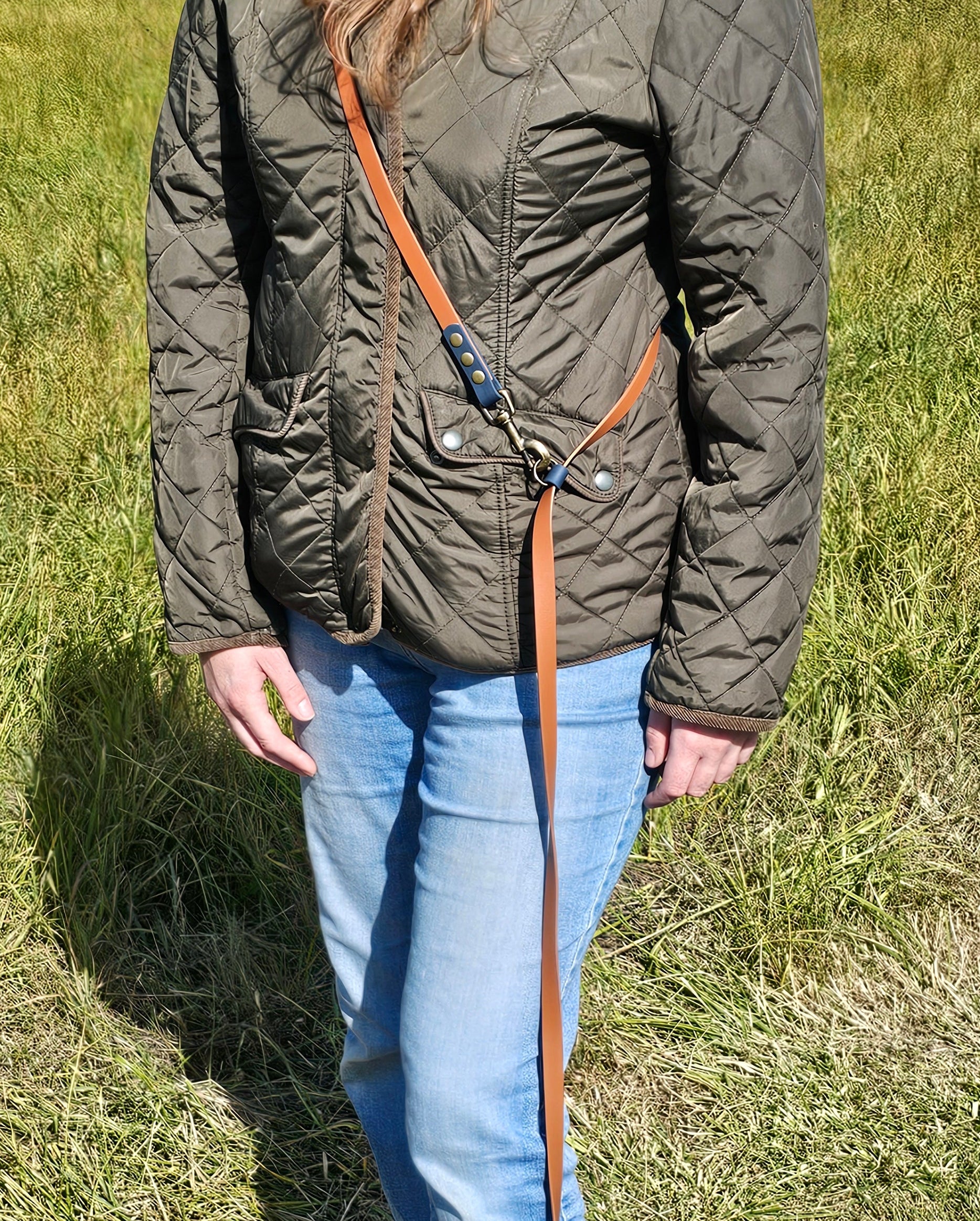 Person wearing cross-body dog lead with a dog attached to leash